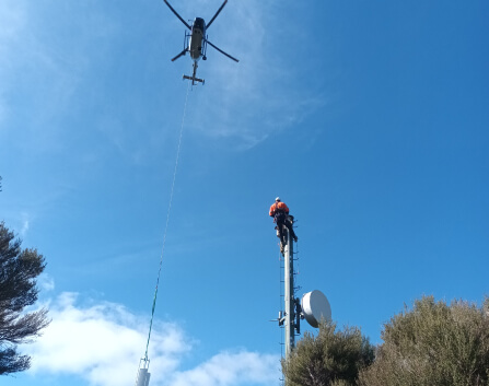 helecopter flying over telecommunications pole