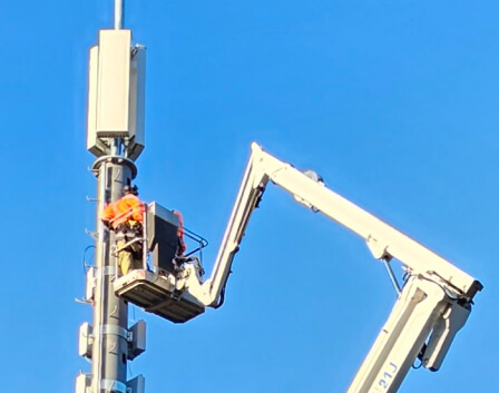 person fixing telecommunications pole